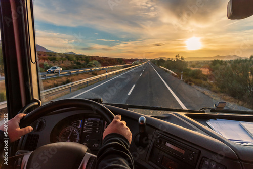 View from the driver's seat of a truck of the highway and a landscape of fields at dawn, with a dramatic sky Fototapet