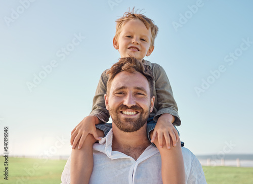 Family, father and child with smile at nature park for fun, relax and freedom with a blue sky. Portrait of happy man and playful boy kid outdoor for love, piggyback and bonding on a summer vacation
