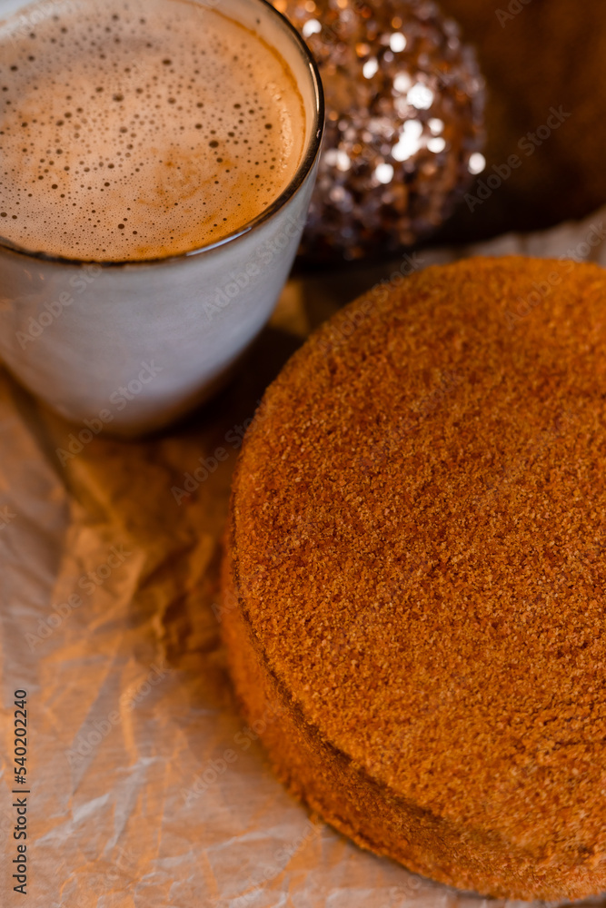 coffee in a designer mug and homemade honey cake on a wooden table in a New Year atmosphere. cozy christmas, cozy winter. High quality photo coffee in a designer mug and homemade honey cake on a wooden table in a New Year atmosphere. cozy christmas, cozy winter. High quality photo