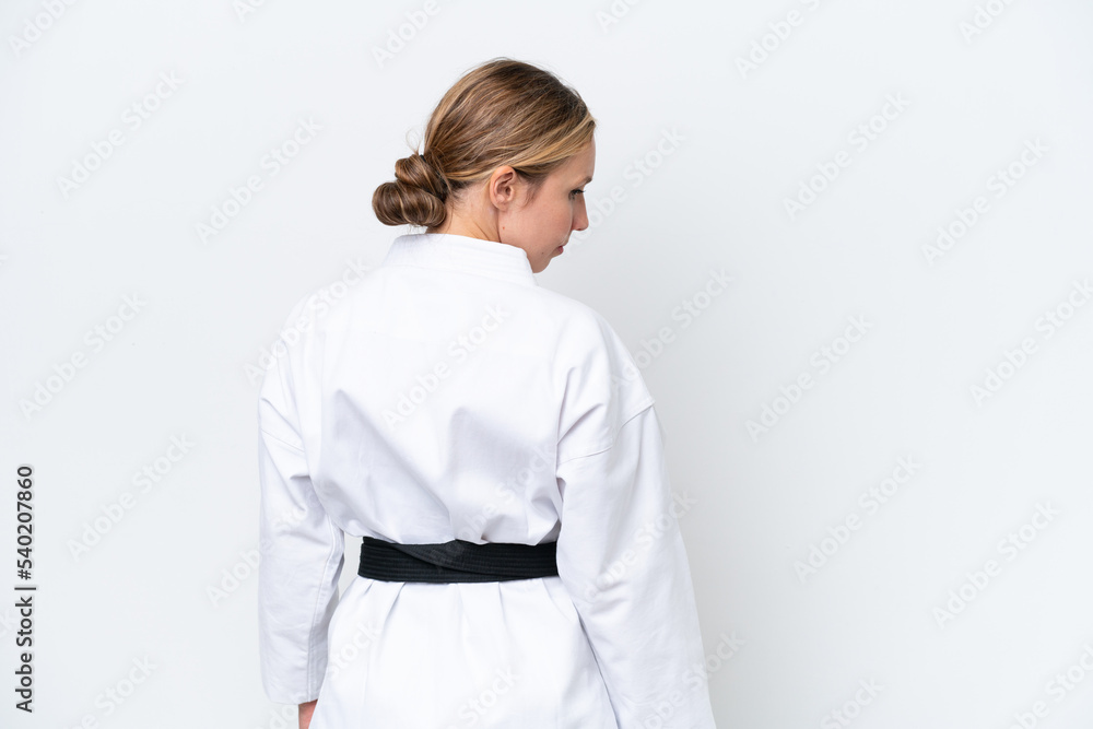 Young caucasian woman isolated on white background doing karate in back position Young caucasian woman isolated on white background doing karate in back position
