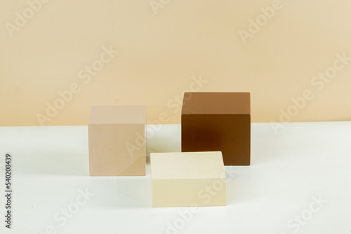 3d podium in the form of a cube of various sizes in earth tone color, with a brown and white background