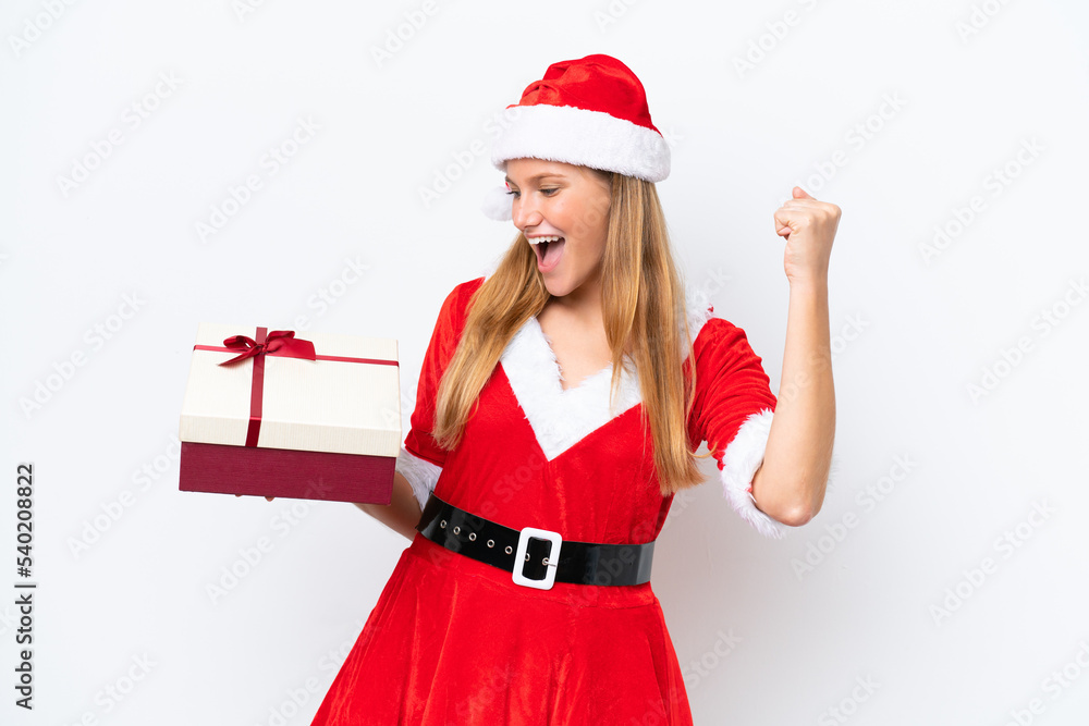 Young caucasian woman dressed as mama noel holding gift isolated on white background celebrating a victory Young caucasian woman dressed as mama noel holding gift isolated on white background celebrating a victory