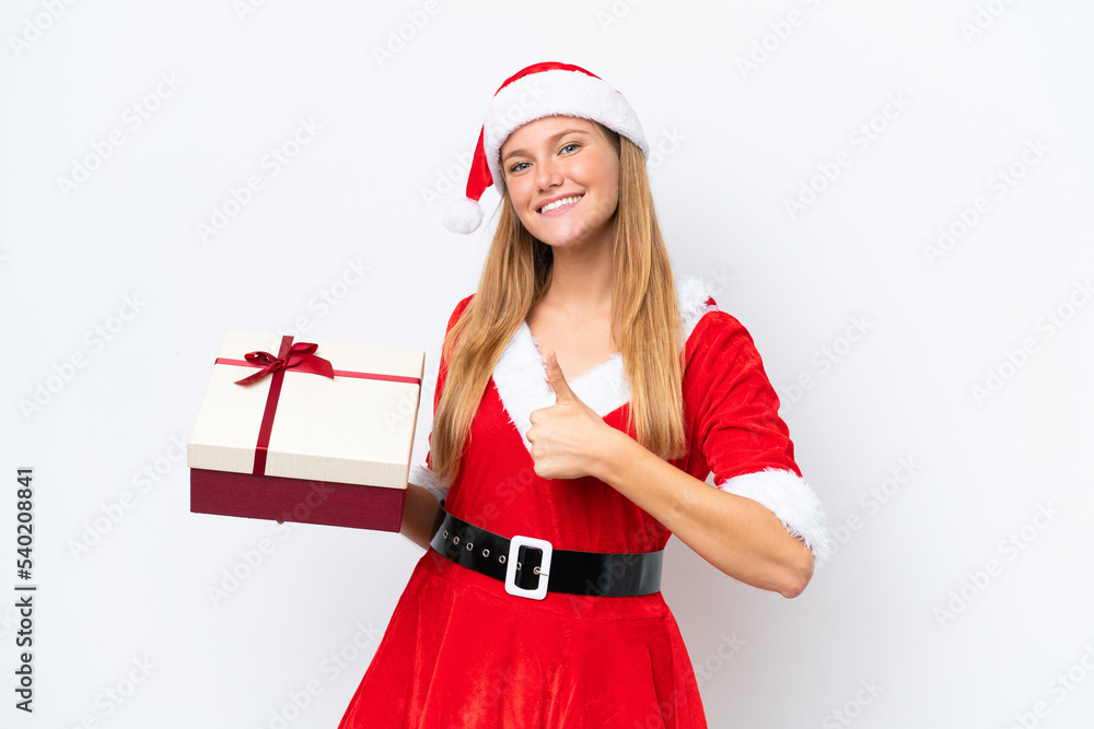 Young caucasian woman dressed as mama noel holding gift isolated on white background with thumbs up because something good has happened Young caucasian woman dressed as mama noel holding gift isolated on white background with thumbs up because something good has happened