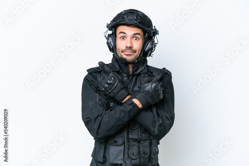 Young caucasian SWAT man isolated on white background pointing to the laterals having doubts © luismolinero