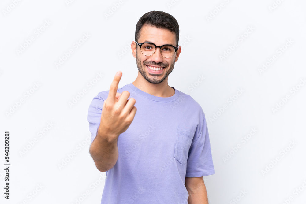 Fototapeta premium Young caucasian man isolated on white background doing coming gesture