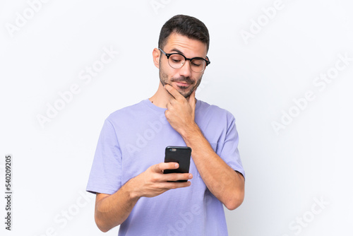 Young caucasian man isolated on white background thinking and sending a message © luismolinero