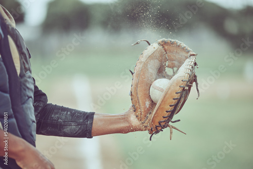 Baseball, sports and catch with a man athlete catching a ball at a game on a field or grass pitch. Fitness, health and sport with a male baseball player playing a match at a sport venue for exercise