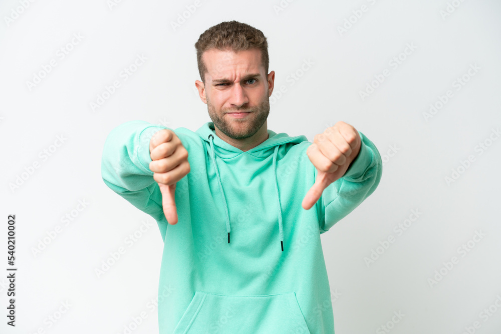 Young handsome caucasian man isolated on white background showing thumb down with two hands Young handsome caucasian man isolated on white background showing thumb down with two hands