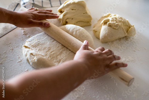 African American woman, Black woman hands rolling yeast dough with wooden French rolling pin, pizza, bread photo