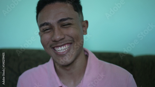 One hispanic man laughing and smiling. A casual latin south american guy real life laugh