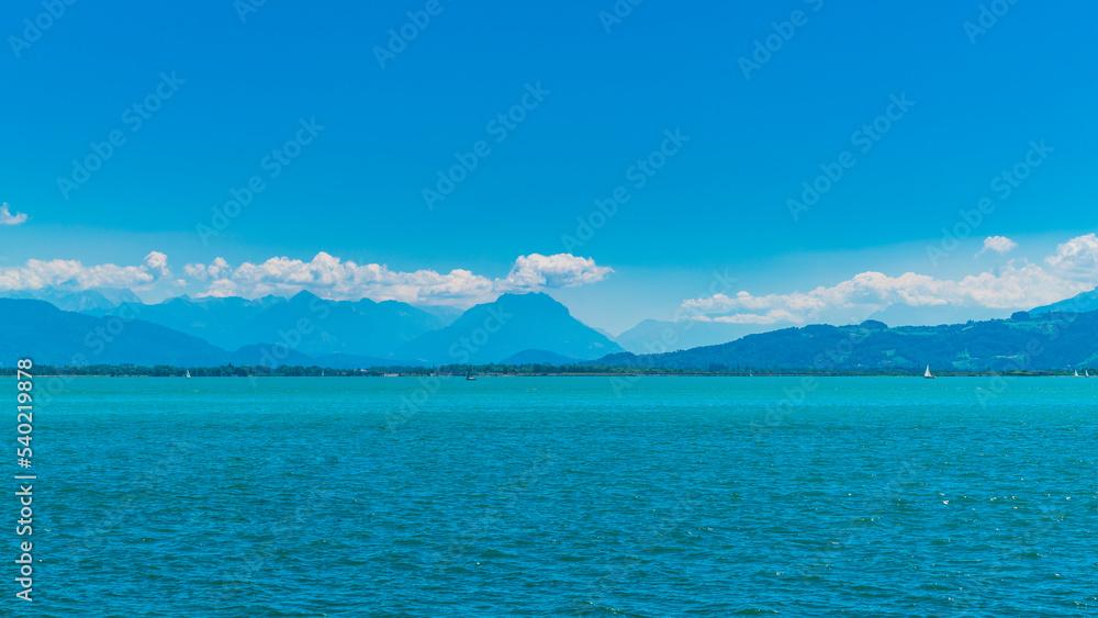 Germany, Beautiful panorama view bodensee blue lake water to austrian and switzerland coast from lindau with many sailboats on the lake on sunny day
