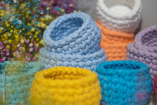 close-up of a beautiful colorful crochet baskets on colorful flower background. Handicraft advertising.  a nice hobby in the winter evenings. Sustainable, organic lifestyle advertising.  © Silga