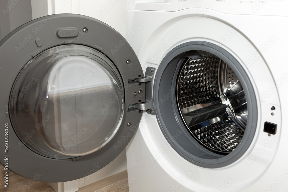 Modern white steel open washing machine close-up. Modern white steel open washing machine close-up.