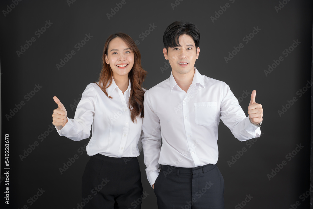 Two young businessmen raising their thumbs forward. Two young businessmen raising their thumbs forward.