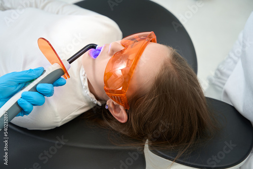 Little patient getting photopolymer filling on central incisor