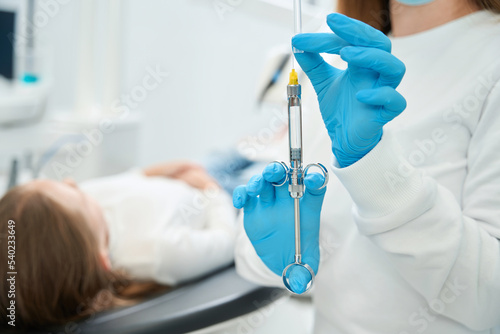 Dentist preparing to administer local anesthetic to patient photo