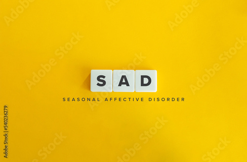 Seasonal affective disorder (SAD) banner. Winter Depression. Block Letter Tiles on Yellow Background. Minimal Aesthetics. photo