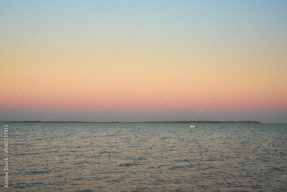 Obraz premium Breathtaking view of pastel pink sunrise while looking towards the Isle of Sheppey in Kent, UK
