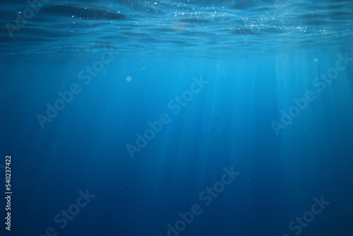 ocean underwater rays of light background, under blue water sunlight © kichigin19