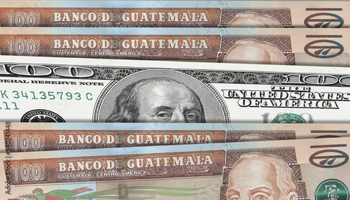 Guatemalan quetzal and US 100 bill. Close up Guatemalan banknotes and US banknotes. 