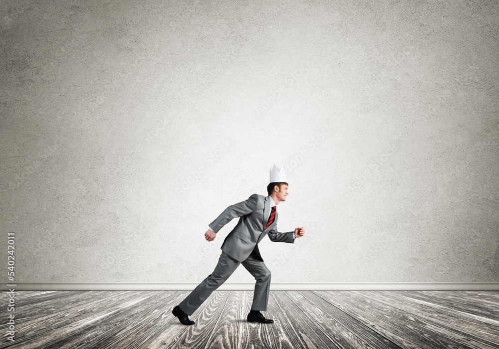 King businessman in elegant suit running in empty room King businessman in elegant suit running in empty room
