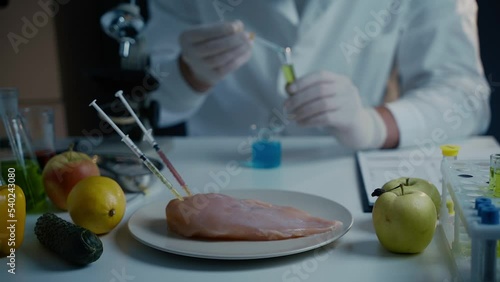 Fresh vegetables, fruits, meat on table and scientist proceeding quality control in laboratory. Genetic engineering laboratory. GMO food concept. Injection into fresh meat. Genetic engineering.