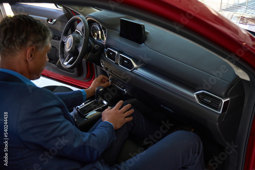 Male person examining red car for purchase © Svitlana