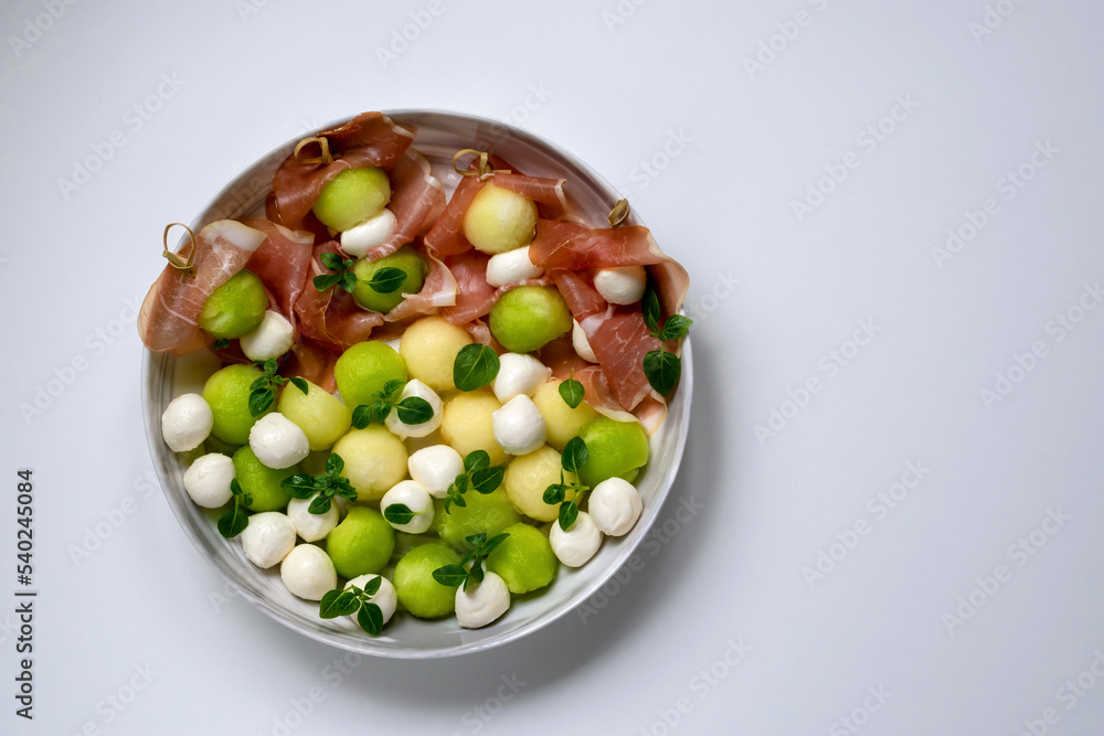 Parma ham with melon on a skewer, mozzarella and basil on a plate are ideal for parties, appetizers. Parma ham with melon on a skewer, mozzarella and basil on a plate are ideal for parties, appetizers.