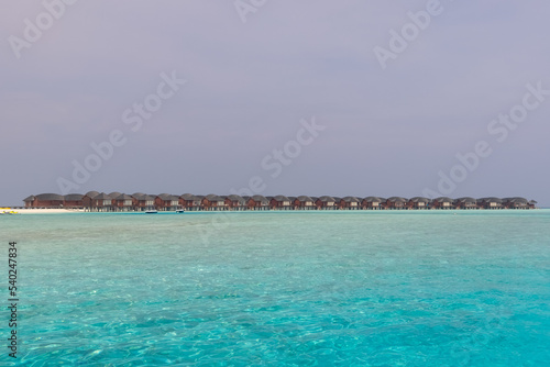 Panorama of Water Villas  Bungalows  and wooden jetty at Tropical beach in the Maldives at summer day