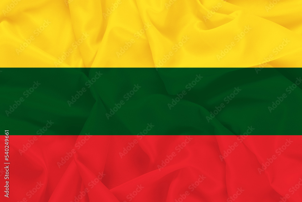 The flag of the European country of Lithuania on a fabric background with waves The flag of the European country of Lithuania on a fabric background with waves