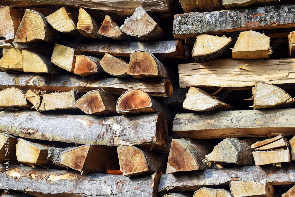 Chopped firewood is stacked in neat piles. Woodpile. Background. Close-up. Selective focus. Chopped firewood is stacked in neat piles. Woodpile. Background. Close-up. Selective focus.