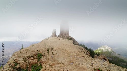 Foggy view from Gran Canaria Roque Nublo, cloudy rock. Hikers at the Roque Nublo monolith in Gran Canaria, Spain. 
 photo