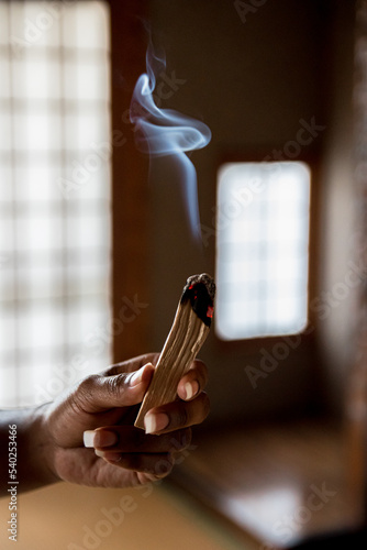 Black woman, African American woman hand holding ember lit and aromatic smoking palo santo wood
