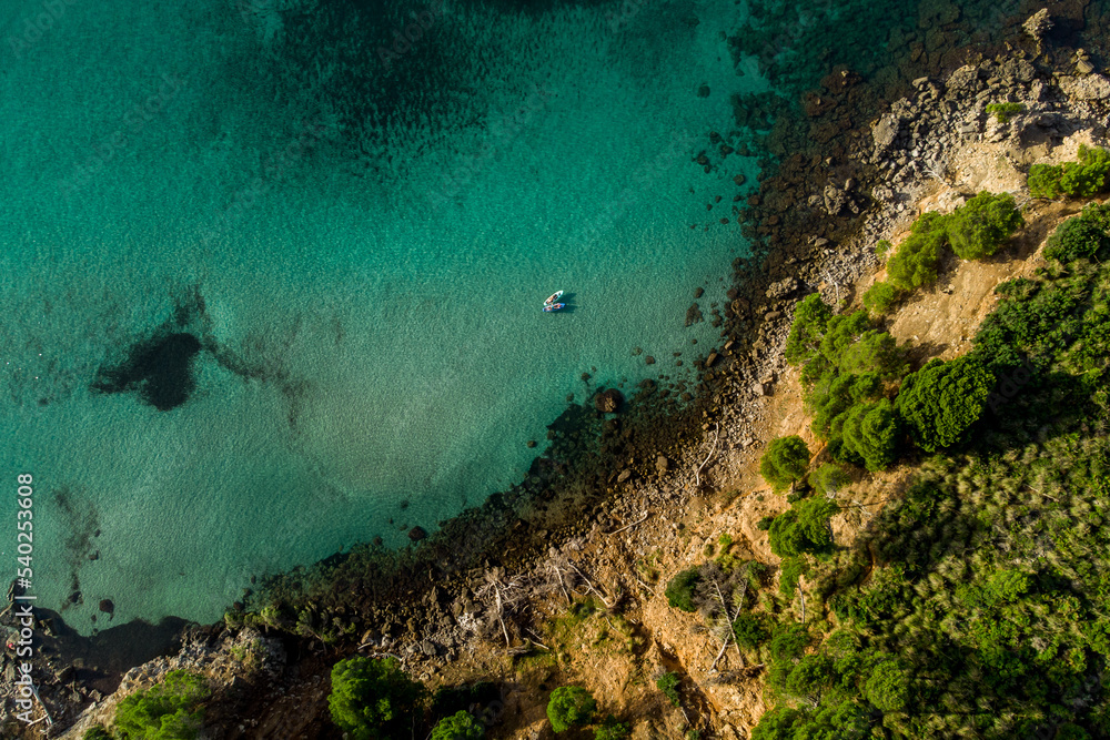 Aerial view of a rocky beach with calm and turquoise sea water with two paddle surfs floating