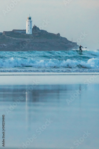 lighthouse on the coast with surfer