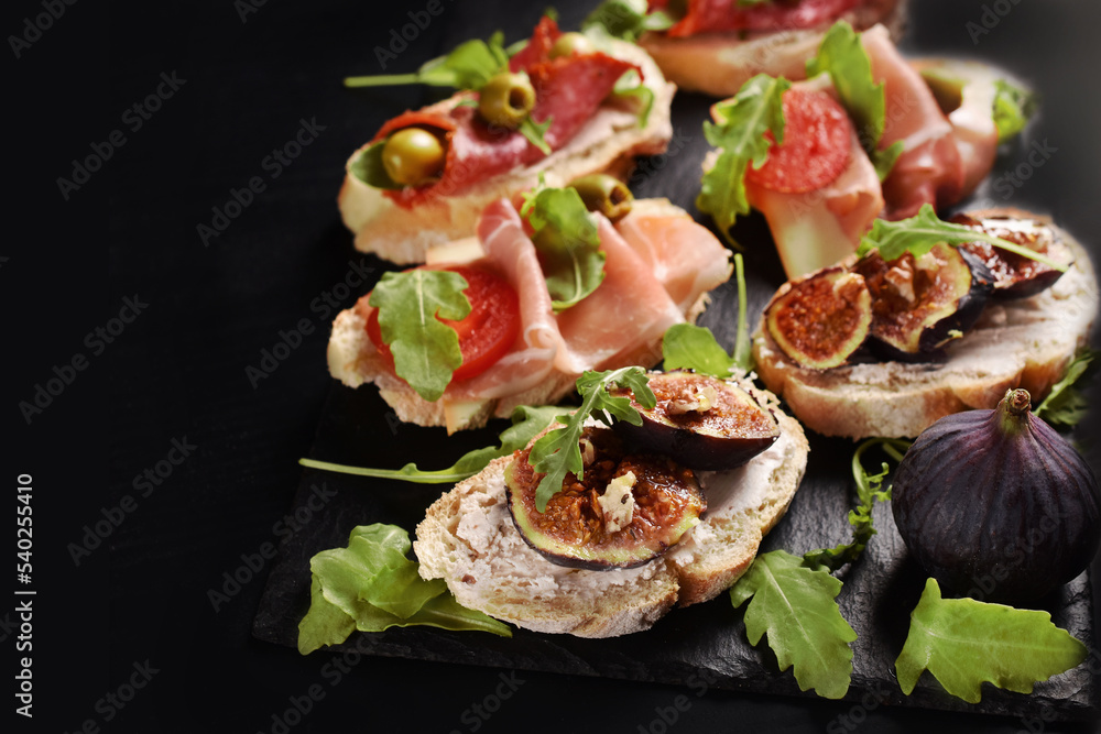 Delicious sandwiches on black board with copy space on left Delicious sandwiches on black board with copy space on left