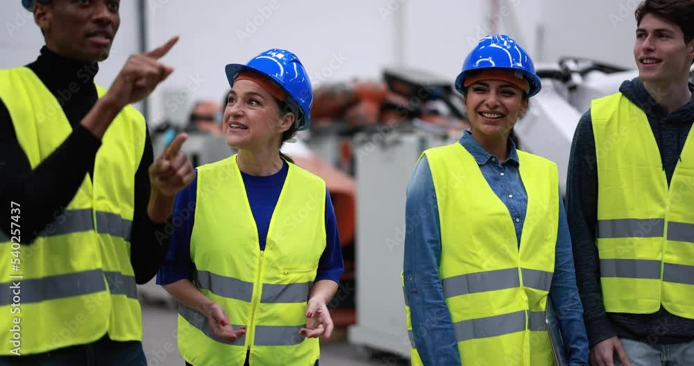 Multiracial engineers working inside robotic factory Multiracial engineers working inside robotic factory