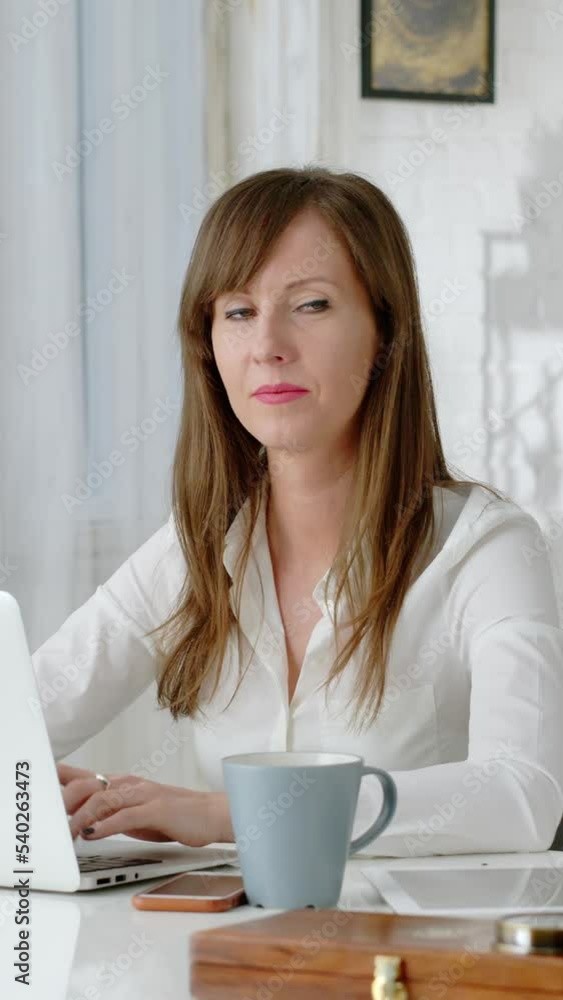 Young business woman working at desk with laptop computer in home office. Getting and reviewing documents. Young business woman working at desk with laptop computer in home office. Getting and reviewing documents.