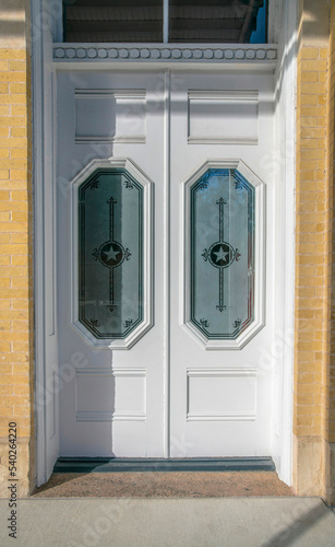 Austin, Texas- Classic white front double door with ornate glass panels and transom