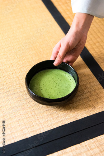Japanese woman, tea master, Sen Rikyu hand serving matcha tea in chawan tea bowl