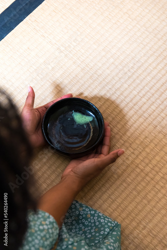 Black woman hands returning chawan tea bowl after drinking matcha tea during Japanese traditional tea ceremony 
