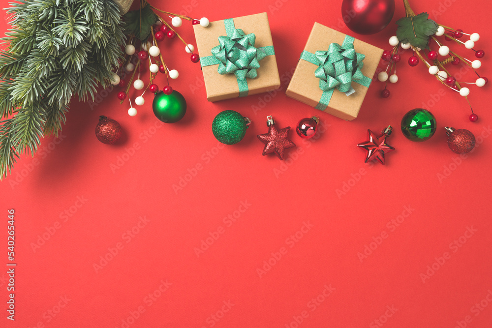 Christmas and New Year greeting card with gift box, ornaments and decorations on red background.  Top view, flat lay