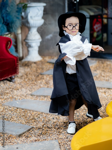 Asian children boy in Count Dracula dress costume for Halloween decoration in graden