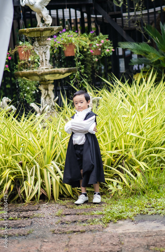 Asian children boy in Count Dracula dress costume for Halloween decoration in graden