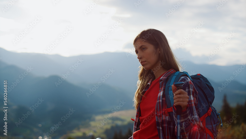 Closeup tired traveler going nature. Beautiful woman wear backpack in mountains.
