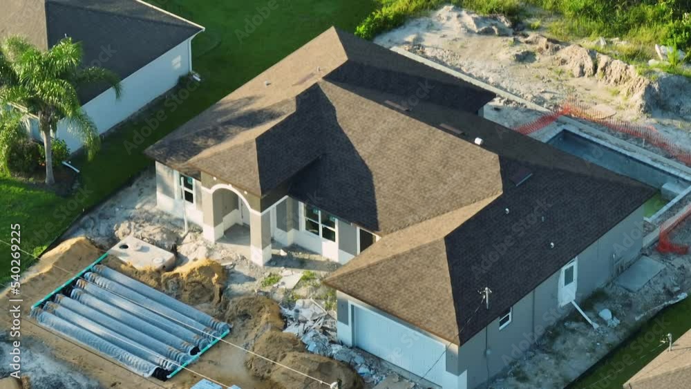 Aerial view of residential private home under construction and yard ground works with septic drain field installation in Florida quiet rural area. Real estate development concept Aerial view of residential private home under construction and yard ground works with septic drain field installation in Florida quiet rural area. Real estate development concept
