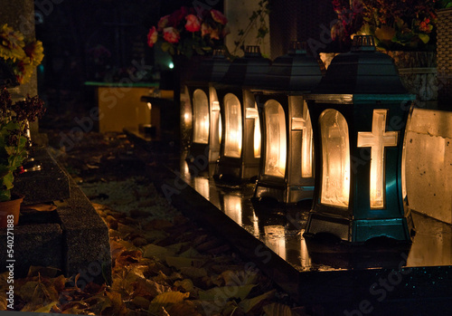 a candles with crucifix in the cemetery on the grave at night, all Saints Day