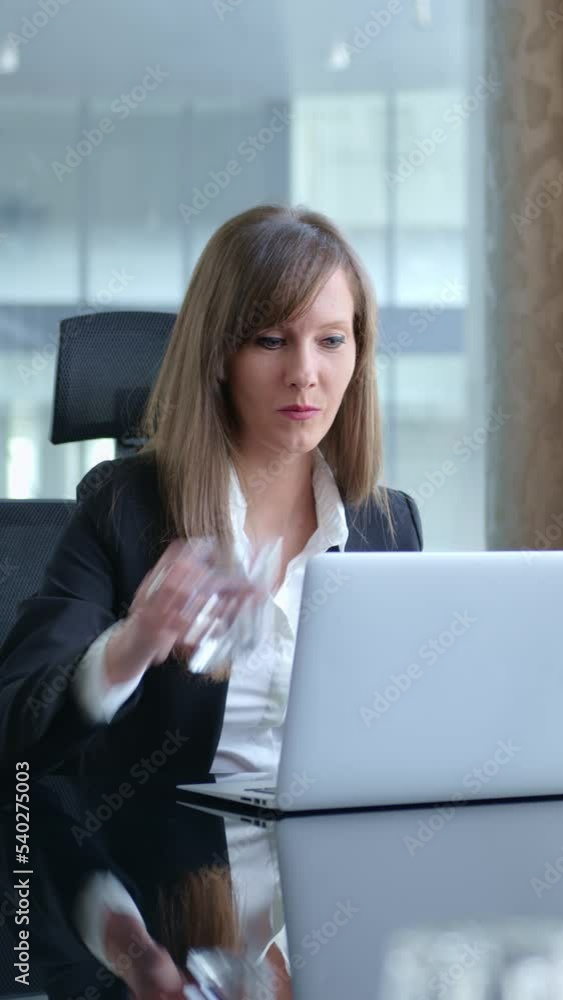 Businesswoman working at desk with laptop computer in corporate office, thinking, looking busy. 4K video footage. Businesswoman working at desk with laptop computer in corporate office, thinking, looking busy. 4K video footage.