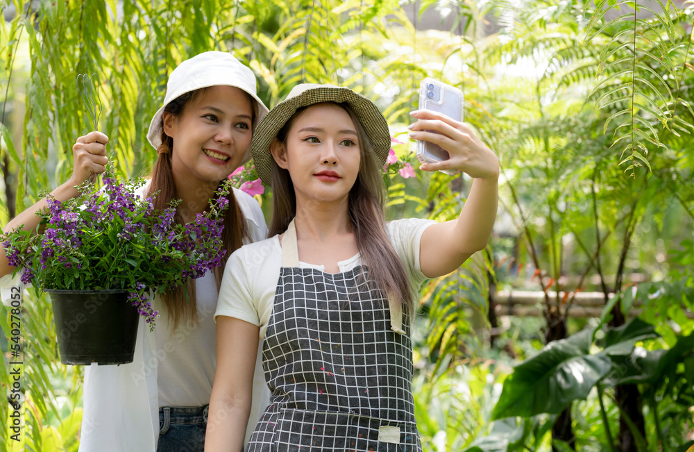 Fototapeta premium Asian women chat online to sell flower plants.
