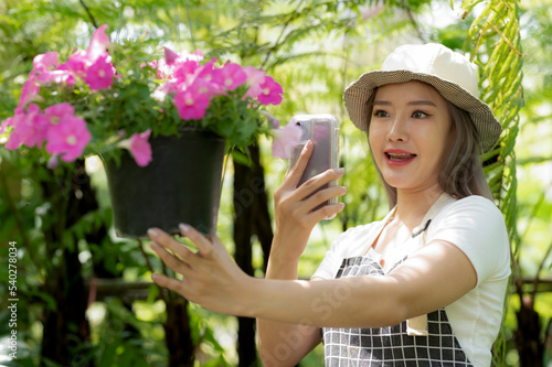 Asian women chat online to sell flower plants.